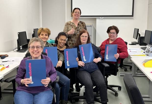 Een groep cursisten aan de cursus basisvaardigheden houdt het diploma omhoog