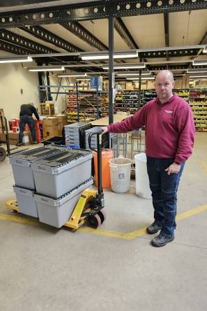 een Westrom-medewerkster werkt op locatie bij Volta Limburg in het magazijn